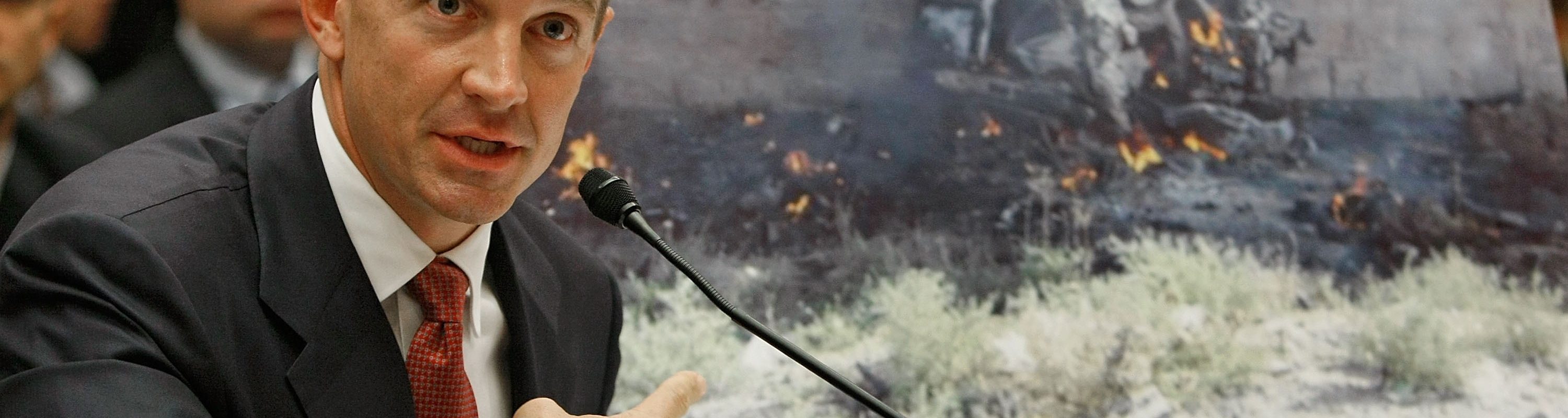 Erik Prince, chairman of the Prince Group, LLC and Blackwater USA, holds up a picture showing the damage inflicted by a car bomb while testifying during a House Oversight and Government Reform Committee hearing on Capitol Hill October 2, 2007 in Washington DC.