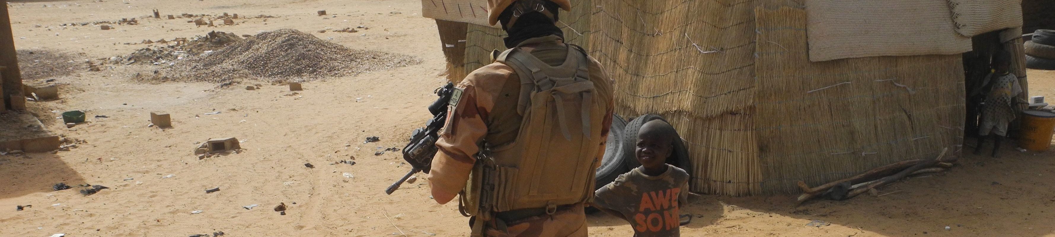 A French soldier looks at a child as he patrols in the streets of Gossi, center Mali, on March 25, 2019.
