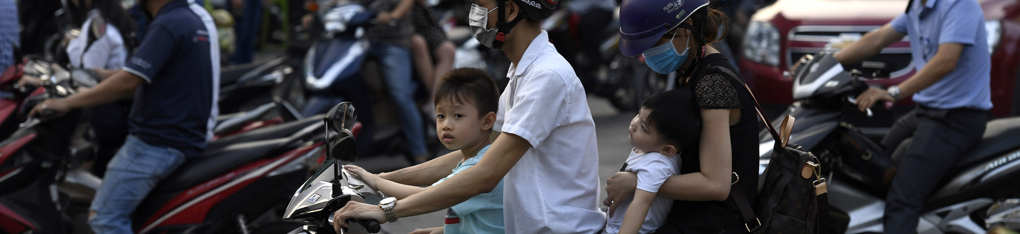 This picture taken on April 19, 2018 shows commuters on mopeds along a street in central Ho Chi Minh City.