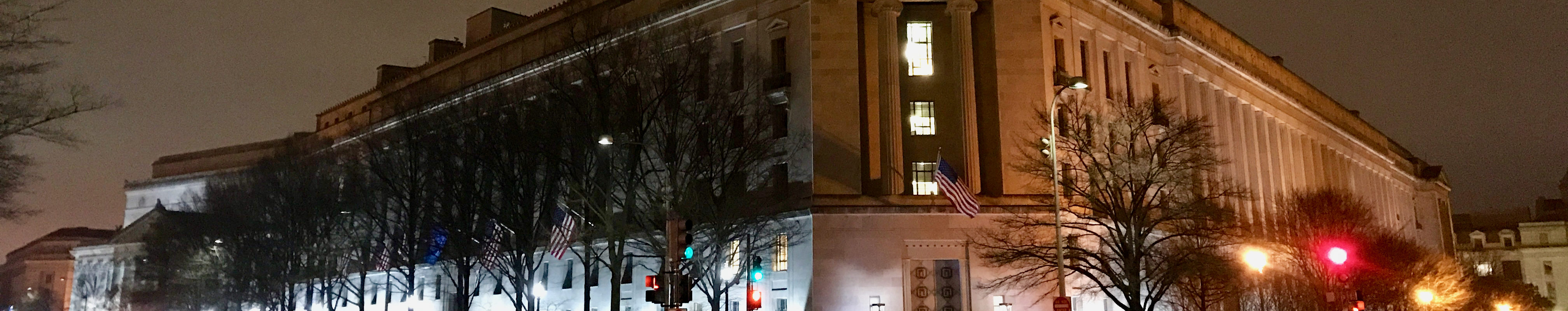 US Department of Justice building at night.