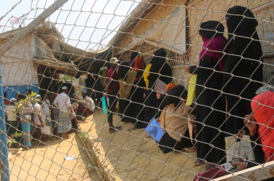 Rohingya refugees, without wearing any mask or any other safty gear as a preventive measure against the COVID-19 novel coronavirus, wait in a relief distribution point at Kutupalong refugee camp in Ukhia March 24, 2020.