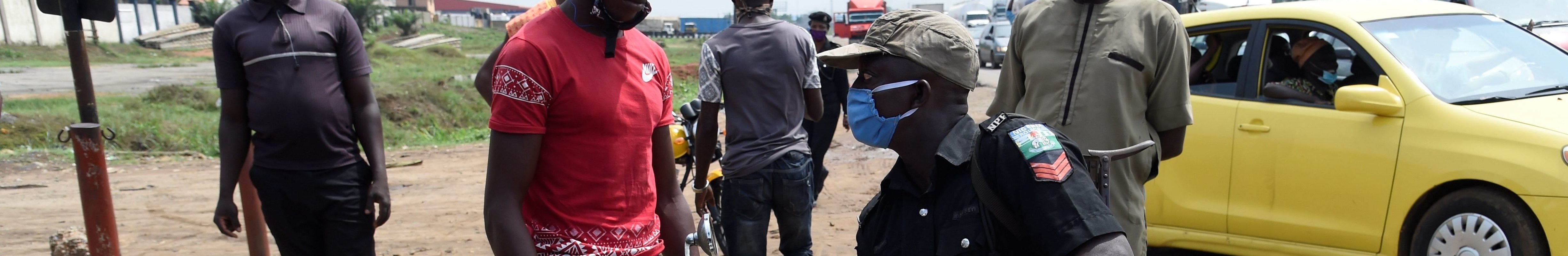 A police officer sits on an impounded power bike and interrogates the owner for failing to comply with the sit-at-home order to prevent the spread of COVID-19 coronavirus on Lagos Ibadan expressway, on April 28, 2020.
