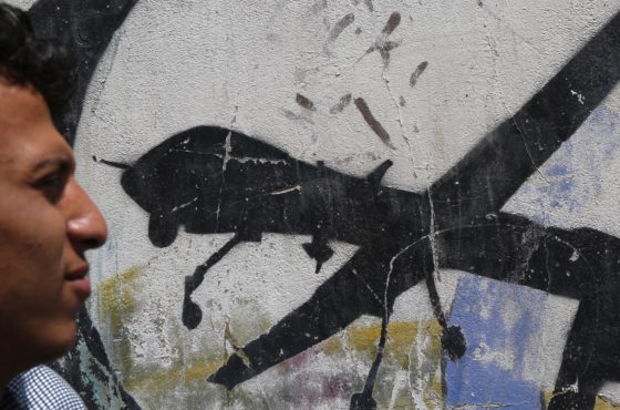 A Yemeni man looks at graffiti protesting against US drone strikes on September 19, 2018 in Sana'a, Yemen.