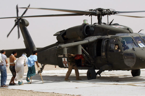 Injured Iraqis classified as enemy prisoners of war walk into a medevac helicopter as they are transferred from the 28th Combat Support Hospital, about 25 kilometers south west of Baghdad, 15 July, 2003, to Camp Cropper, a prison camp at the Saddam International Airport in Baghdad.