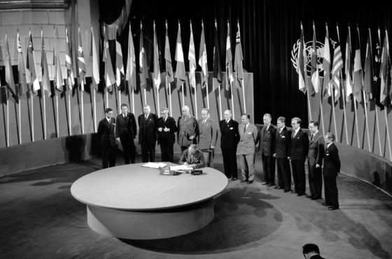 Norway signs the United Nations Charter and other country representatives stand behind at the The San Francisco Conference, 25 April - 26 June 1945.