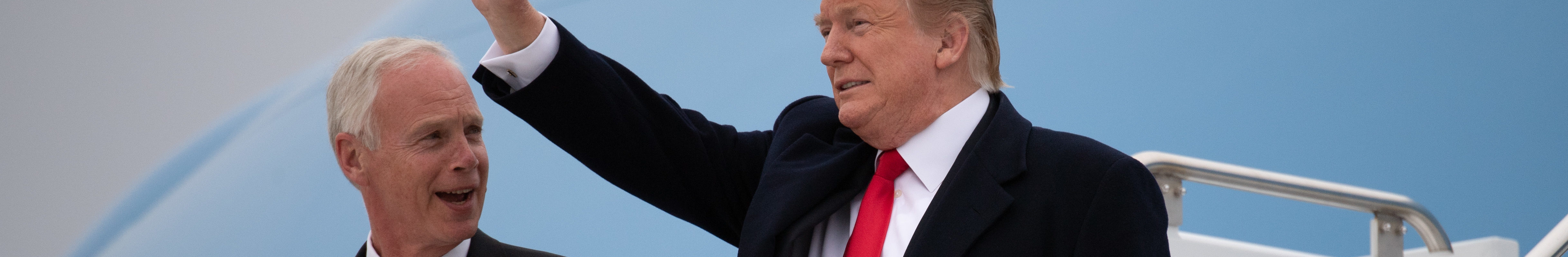 Trump waves as he and US Senator Ron Johnson, Republican of Wisconsin, disembark from Air Force One upon arrival at Green Bay Austin Straubel International Airport in Green Bay, Wisconsin, April 27, 2019, as he travels to hold a Make America Great Again rally.