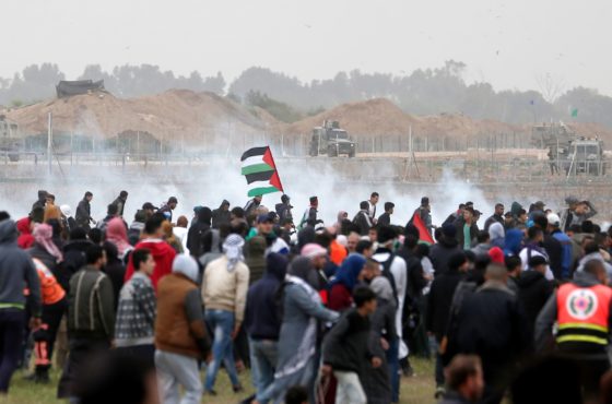 Palestinian protesters run for cover as Israeli forces fire tear gas canisters during clashes following a demonstration marking the first anniversary of the "March of Return" protests, near the border with Israel east of Gaza City on March 30, 2019.