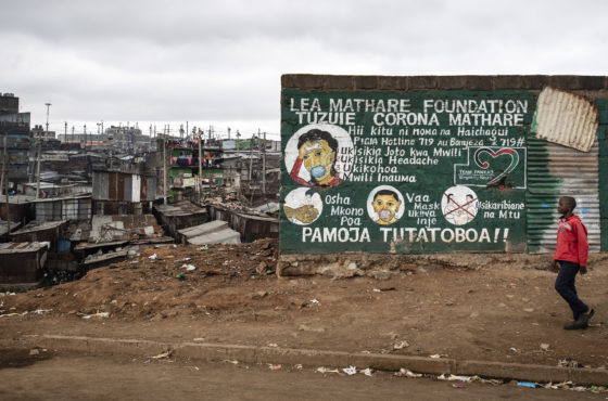 A young boy walks in front of a grafittied wall spelling out the symptoms of and ways to avoid Coronavirus in Mathare informal settlement on July 10, 2020 in Nairobi, Kenya.