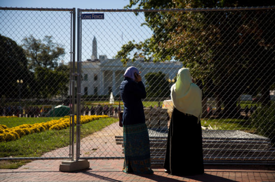 Two Muslim women stand near a fence across the street from the White House before the start of a protest against the Trump administration's proposed travel ban, October 18, 2017 in Washington, DC.