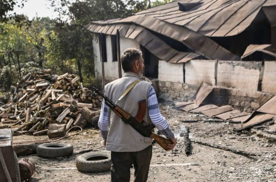 An armed villager arrives at a neighbor’s home destroyed by shelling following an overnight attack during the ongoing fighting between Armenia and Azerbaijan over the disputed region of Nagorno-Karabakh, in the Martakert region on October 15, 2020.