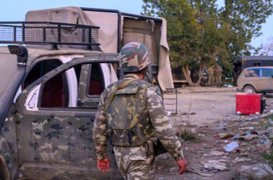 An Azeri soldier walks near a destroyed vehicle in the city of Jabrayil, where Azeri forces regained control during the fighting with Armenia over the breakaway region of Nagorno-Karabakh on October 16, 2020.