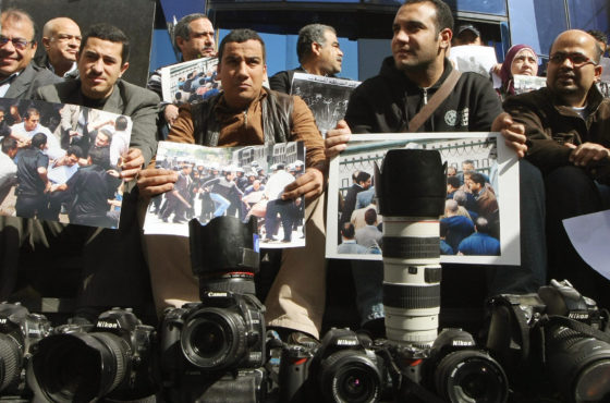 Egyptian members of the press sit outside the headquarters of the journalists syndicate in Cairo on January 25, 2009 with their cameras on the ground, in protest against police interference in their work. Many hold images of police brutality.