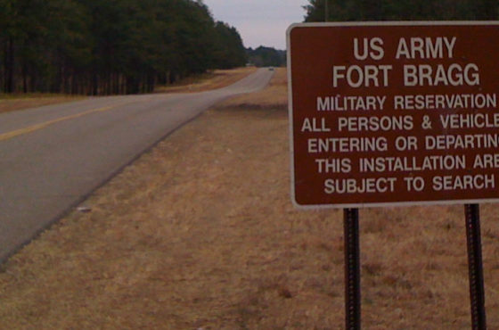 A road sign entering Fort Bragg going from Connecticut Avenue in Southern Pines, North Carolina, in March 2010. The sign reads, “US Army Fort Bragg Military Reservation – All persons and vehicles entering or departing this installation are subject to search.”