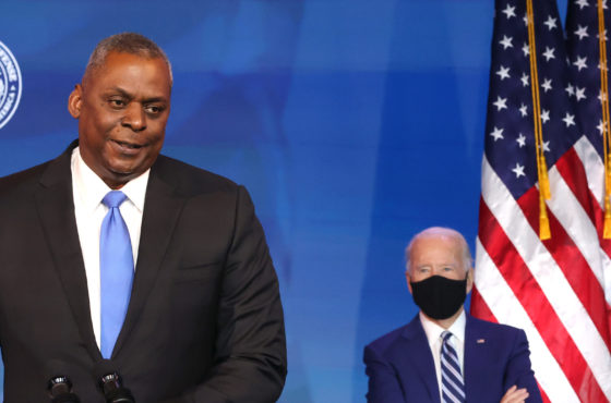 U.S. Army (retired) General Lloyd Austin speaks after being formally nominated to be Secretary of the Department of Defense by U.S. President-elect Joe Biden at the Queen Theatre on December 09, 2020 in Wilmington, Delaware. President-elect Biden wears a face mask and sits socially distanced behind General Austin who does not wear a face mask and speaks at a podium. American flags can be seen behind Biden.