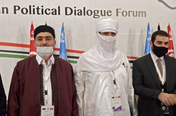 Libyan delegates, including Abdessalam Shuha, Abdallah Shibani, Hussein Mohamed Elansari, an unidentified participant and Abdel Majid Mlayqtah attend the opening of the Libyan Political Dialogue Forum hosted in Gammarth on the outskirts of Tunisia's capital, on November 9, 2020. They stand side by side not socially distanced and wear face masks, though two of them do not wear the face masks properly, ie. not covering their noses.