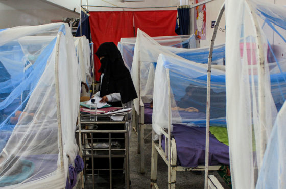 Women wait with children in a ward at a malnourishment treatment centre in Yemen's northern Hajjah province on November 22, 2020. The beds the children lie in are covered in netting, and the walkways between beds are very small since the beds are crowded together.