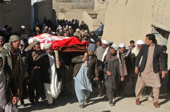 Family members and relatives take part in the funeral procession of Afghan journalist Rahmatullah Nekzad at Khoja Omari district of Ghazni province, on December 22, 2020. The group appears to walk uphill and fills the span of the block.