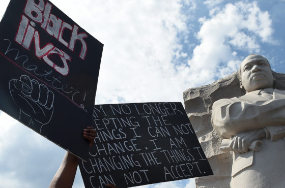 Demonstrators in Washington, DC, on June 4, 2020, raise signs as they gather at The Martin Luther King Jr. Memorial to protest the death of George Floyd, who died in police custody in Minneapolis. One sign reads, “Black Lives Matter,” and another sign reads, “I am no longer accepting the things I can not change. I am changing the things I can not accept.”