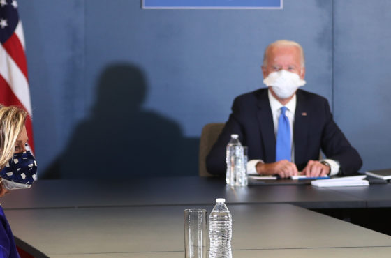 Speaker of the House Nancy Pelosi (D-CA) sits with U.S. President-elect Joe Biden during a meeting that included Vice President-elect Kamala Harris and Senate Democratic Leader Chuck Schumer (D-NY) (not shown) at the Queen Theater on November 20, 2020 in Wilmington, Delaware. They sit at a large horse-shoe or square table allowing ample room for social distancing. An American flag stands behind the table near President-elect Biden.