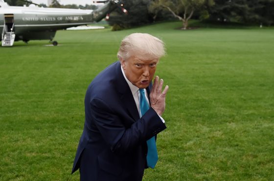Trump whispers to a White House staffer as he makes his way to board Marine One from the South Lawn of the White House in Washington, DC on September 26, 2020.