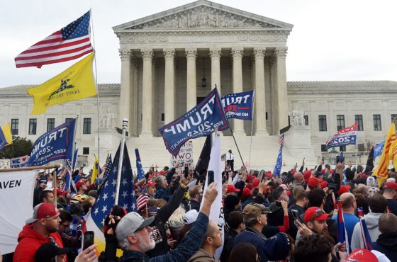 Supporters of US President Donald Trump participate in the Million MAGA March to protest the outcome of the 2020 presidential election, in front of the US Supreme Court on December 12, 2020 in Washington, DC. They carry Trump flags, American flags, and other flags.