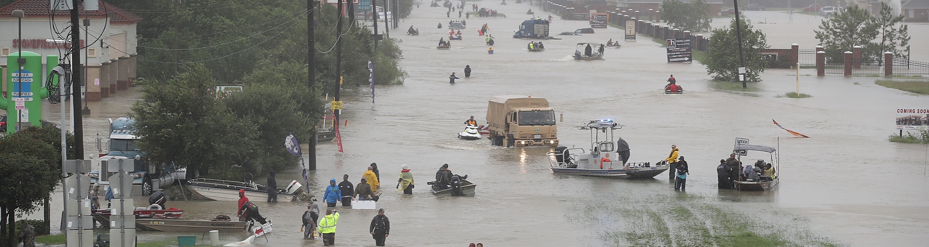 People walk down a flooded street as they evacuate their homes after the area was inundated with flooding from Hurricane Harvey on August 28, 2017 in Houston, Texas. A number of people use rowboats and small motorized boats as well. The flooding appears to be up to people’s waists in some areas of the street and to their knees in the more shallow areas.