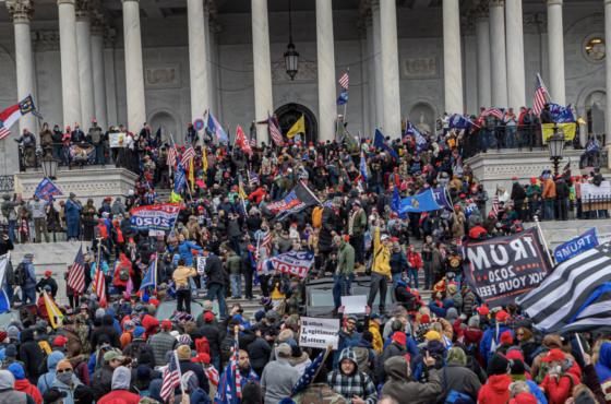 Insurrectionists storm the Capitol Building on January 6, 2021. They waive Trump flags, American flags, police flags, and other white supremacy flags.