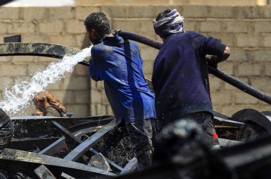 Workers extinguish flames at a warehouse, after it was reportedly hit in an airstrike by the Saudi-led coalition, in the Yemeni capital Sanaa on July, 2, 2020.
