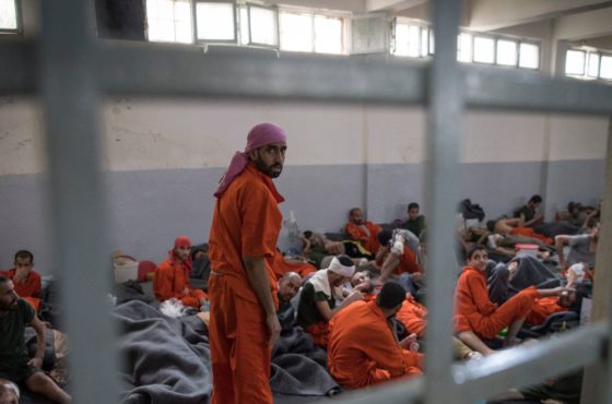 A crowded prison cell in the northeastern Syrian city of Hasakeh on October 26, 2019. Men accused of being affiliated with the Islamic State (IS) group sit and lay on the floor close together. There does not appear to be an empty floor space.