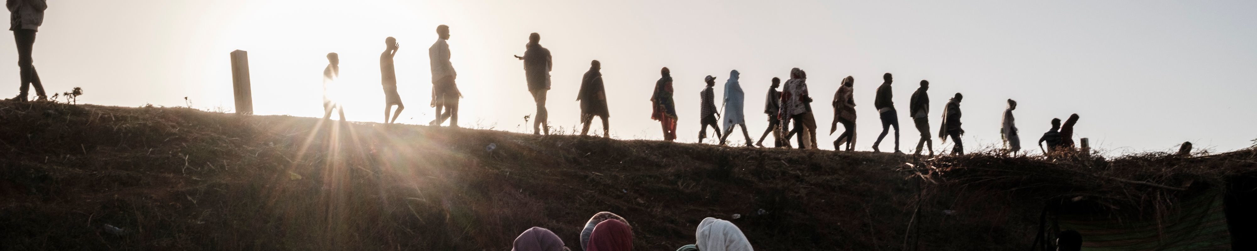 Internally Displaced People, fleeing from violence in the Metekel zone in Western Ethiopia, walk on a route as others stand below in a camp in Chagni, Ethiopia, on January 28, 2021.