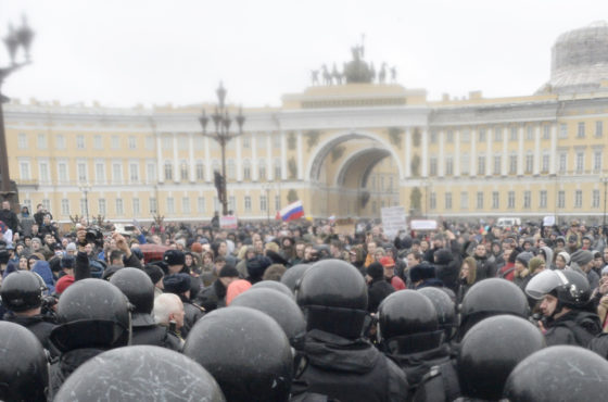 Protestors rally against corruption in central Saint Petersburg on March 26, 2017. Numerous police or military forces in helmets watch the protestors.