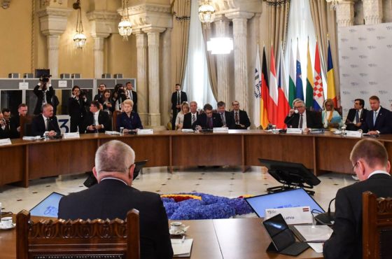 Jean-Claude Juncker, President of the European Commission and representatives of the Three Seas Initiative (3SI or TSI) takes part in a TSI Summit, on September 18, 2018 at the Cotroceni Palace, the Romanian Presidency headquarters in Bucharest. Delegates sit around a large round table, and press can be seen taking photos and video behind many of the delegates.