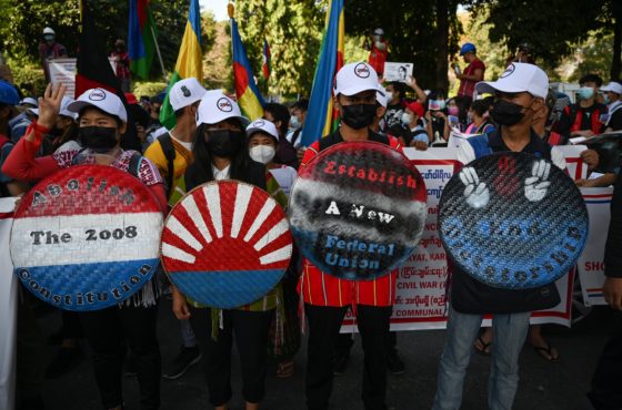Representatives from Karen ethnic group take part in a demonstration against the military coup in Yangon on February 11, 2021. They wear face masks and hold signs that read, “Abolish the 2008 Constitution,” “Establish a new federal union,” and “End censorship.”