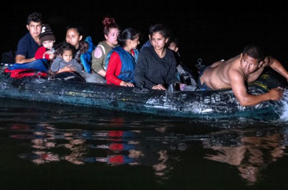 Refugees on an inflatable raft in the dark of night.