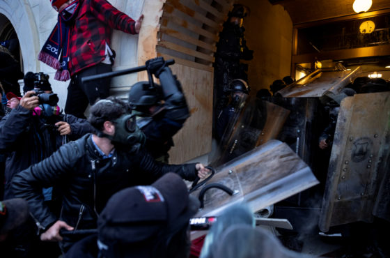 Trump supporters clash with police and security forces as people try to storm the US Capitol on January 6, 2021 in Washington, DC. The insurrectionists wear riot gear as do the police. One insurrectionist raises a police baton attacking the police.